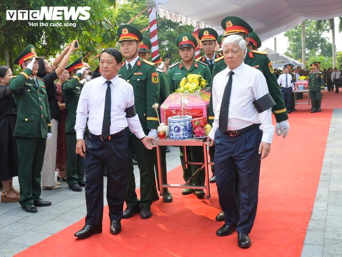 Các đại biểu cùng lực lượng quân đội tiễn đưa hài cốt liệt sĩ về khu an táng. (Ảnh: Tuấn Anh)