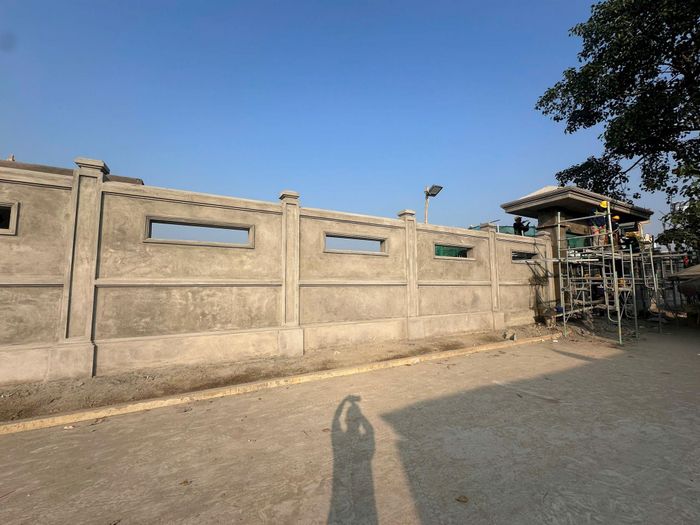 Hạng mục cổng và tường rào bao quanh nghĩa trang ở thôn Thượng Quán đang được gấp rút thi công hoàn thành. Ảnh: PV