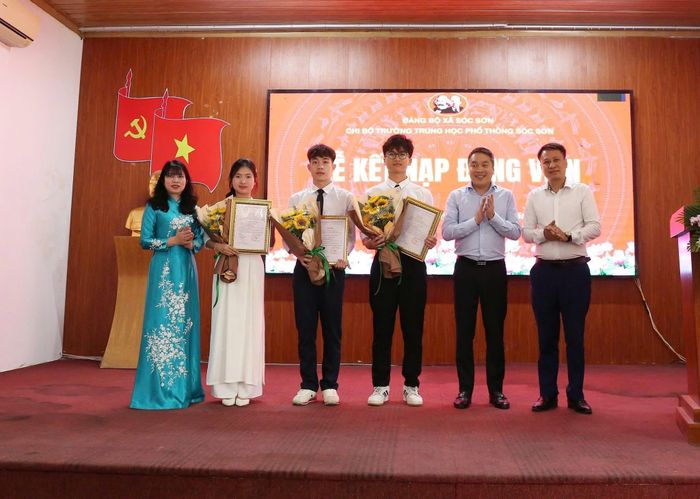 Bí thư Đảng ủy xã Sóc Sơn Bùi Bảo Tuấn trao quyết định kết nạp Đảng cho 3 học sinh Trường THPT Sóc Sơn vào tháng 4-2026. Ảnh: Tùng Nguyễn