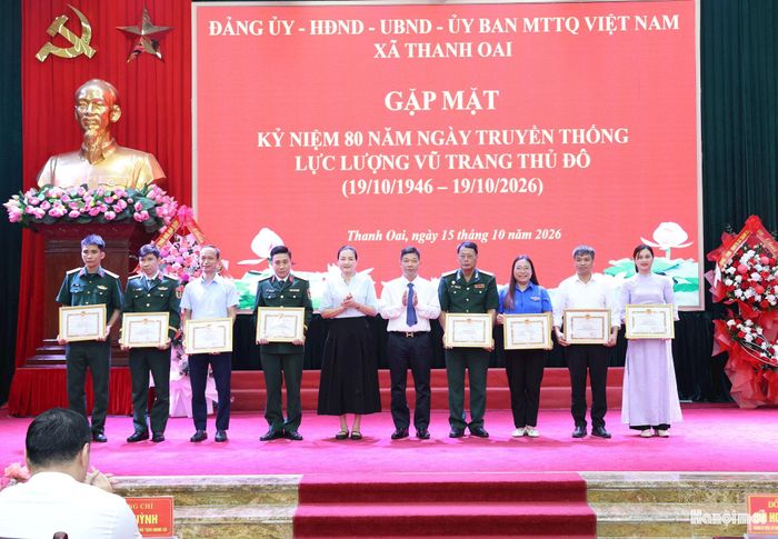 Lãnh đạo xã trao khen thưởng cho cá nhân có thành tích xuất sắc trong thực hiện các nhiệm vụ chào mừng kỷ niệm 80 năm Ngày truyền thống Lực lượng vũ trang Thủ đô trên địa bàn xã. Ảnh: Mai Quý