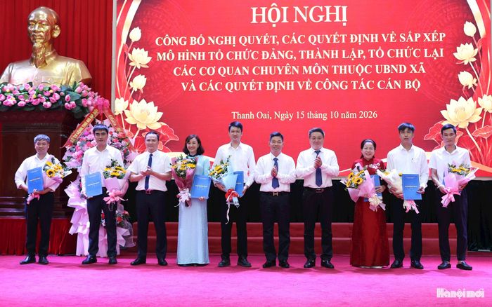 Lãnh đạo xã Thanh Oai trao quyết định và tặng hoa chúc mừng lãnh đạo 5 phòng chuyên môn thuộc UBND xã. Ảnh: Mai Quý