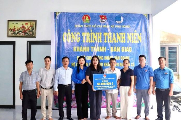 Đại diện cấp ủy Đảng, chính quyền, MTTQ Việt Nam xã Phú Nghĩa trao tặng kinh phí hỗ trợ gia đình ông Hoàng xây nhà. Ảnh: Kim Thoa 