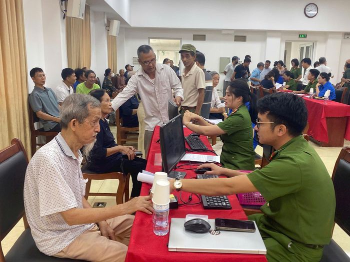 Cán bộ công an tận tình hướng dẫn thân nhân liệt sĩ kê khai thông tin. Ảnh: Thu Hiền