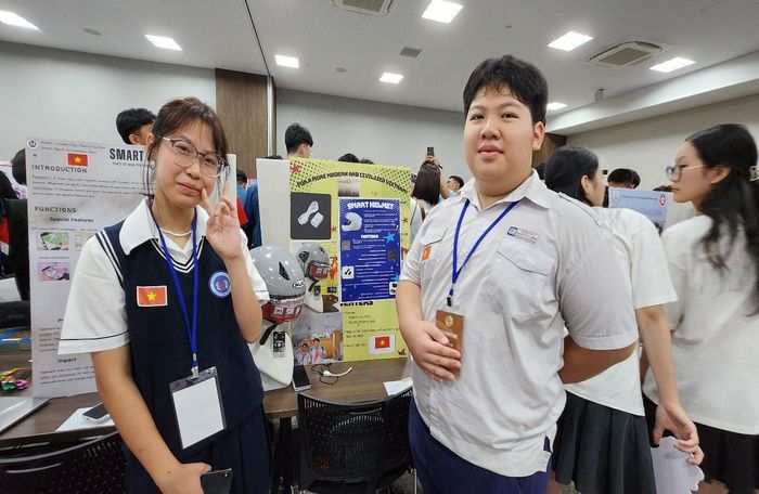 Phương Linh và Đức Phát bên mô hình “Mũ bảo hiểm thông minh” tại JDIE 2024 ở Tokyo. Ảnh: Nguyễn Trang