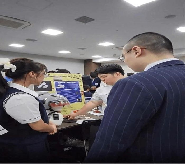 Phương Linh và Đức Phát giới thiệu mô hình “Mũ bảo hiểm thông minh” với Ban Giám khảo tại JDIE 2024 ở Tokyo. Ảnh: Phương Dung.