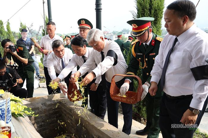 Các đại biểu thả hoa tiễn biệt các liệt sĩ về nơi an nghỉ cuối cùng. Ảnh: Tuấn Anh