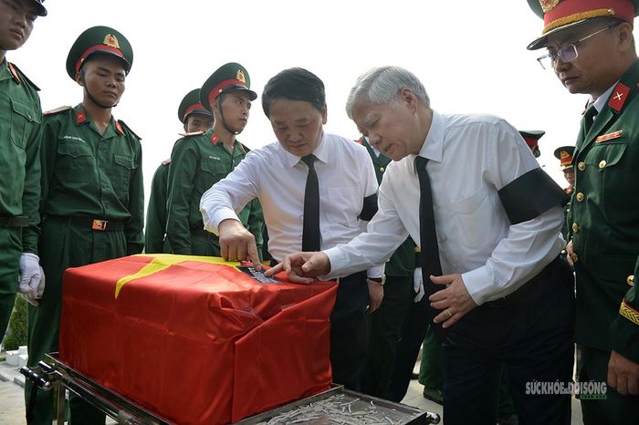 Các đại biểu xem thông tin trên tiểu sành đựng hài cốt liệt sĩ. Ảnh: Tuấn Anh