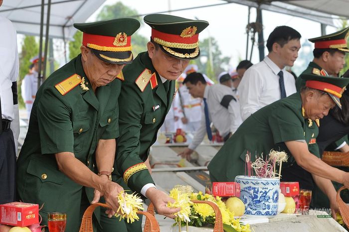 Cán bộ quân đội thành kính thả những cánh hoa vàng xuống phần mộ. Ảnh: Tuấn Anh