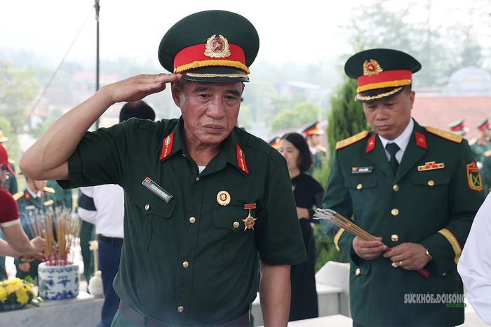 Người cựu chiến binh giơ tay chào tiễn biệt đồng đội. Ảnh: Tuấn Anh