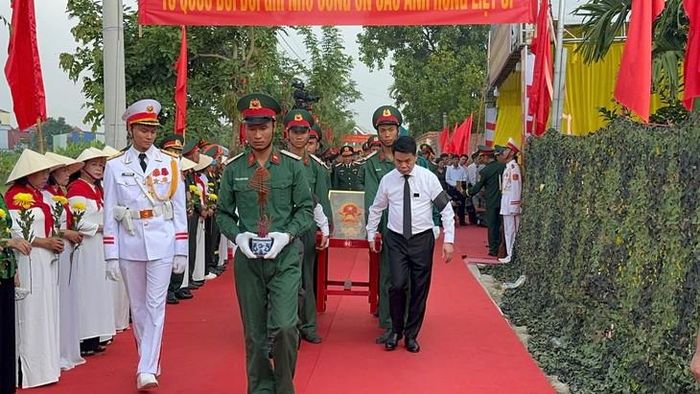 Các đại biểu thực hiện nghi lễ di chuyển hài cốt liệt sĩ. Ảnh: Tiến Sinh