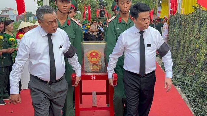 Các đại biểu thực hiện nghi lễ di chuyển hài cốt liệt sĩ. Ảnh: Tiến Sinh
