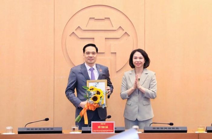 Bà Vũ Thu Hà, Thành ủy viên, Phó Chủ tịch UBND thành phố Hà Nội trao quyết định và chúc mừng tân Phó Giám đốc Sở Y tế Nguyễn Đức Long. Ảnh: Linh Linh.