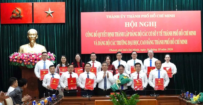 Ông Nguyễn Phước Lộc (ở giữa), Phó bí thư Thành ủy, Chủ tịch Ủy ban MTTQ Việt Nam TP.HCM trao quyết định và tặng hoa chúc mừng Ban Chấp hành Đảng bộ các trường đại học, cao đẳng TP.HCM; Đảng bộ các cơ sở y tế TP.HCM. Ảnh: Nguyên Nguyên.