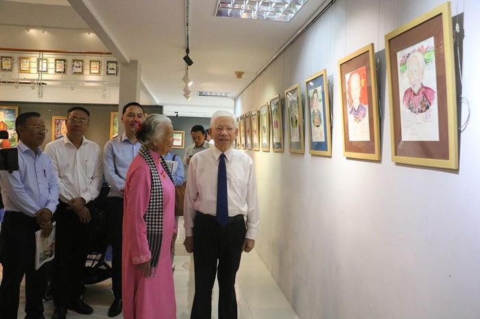 Họa sĩ Đặng Ái Việt giới thiệu chân dung các Mẹ Việt Nam Anh hùng trưng bày tại triển lãm với nguyên Chủ tịch nước Nguyễn Minh Triết và các đại biểu