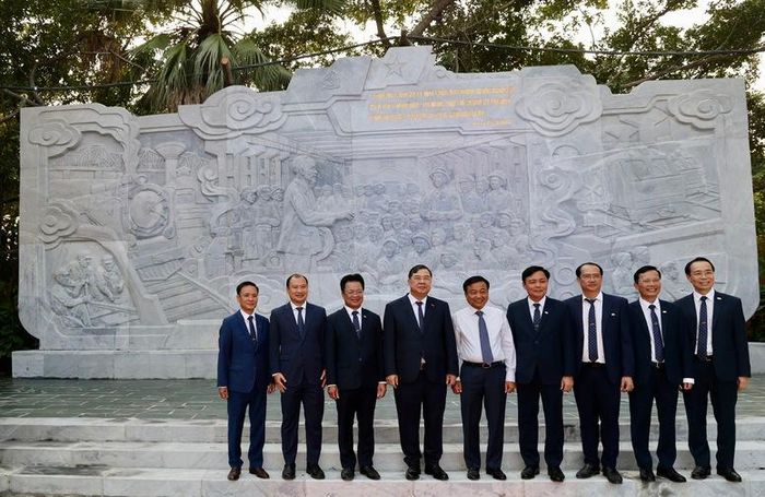 Phó Thủ tướng Thường trực Chính phủ Phạm Gia Túc và các đại biểu chụp ảnh lưu niệm dưới bức phù điêu Bác Hồ nói chuyện với công nhân hoả xa - Ảnh: chinhphu.vn/Phương Nguyên