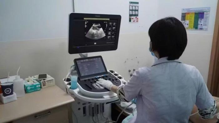 Nhân viên y tế siêu âm tầm soát ung thư miễn phí cho phụ nữ yếu thế.