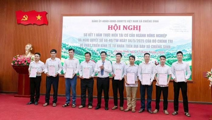 Đồng chí Đỗ Văn Sơn, Chủ tịch Ủy ban nhân dân xã Chiềng Sinh trao giấy chứng nhận quyền sử dụng đất cho các hộ dân trên địa bàn. (Ảnh: LÊ LAN)