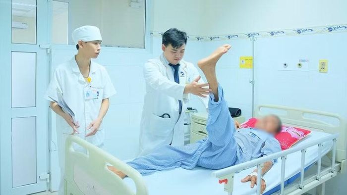 Các bác sĩ vật lý trị liệu-phục hồi chức năng hướng dẫn các bài tập tăng cường sức cơ hai chân cho ông T.V.N. (Ảnh: Bệnh viện cung cấp)