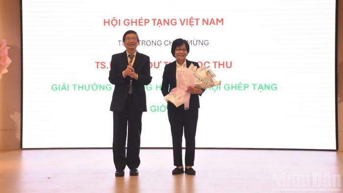 Giáo sư, Tiến sĩ Phạm Gia Khánh, Chủ tịch Hội Ghép tạng Việt Nam tặng hoa chúc mừng Tiến sĩ, bác sĩ Chuyên khoa II Dư Thị Ngọc Thu, Trưởng Đơn vị Điều phối ghép các bộ phận cơ thể người, Bệnh viện Chợ Rẫy vinh dự nhận Giải thưởng Unsung Hero 2026 (Người anh hùng thầm lặng) do Hội Ghép tạng Thế giới (TTS) trao tặng. (Ảnh: ANH ĐÀO)
