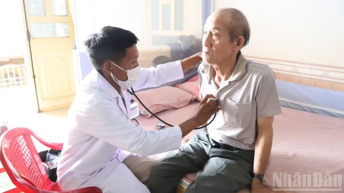 Cán bộ Trạm Y tế xã Ea M'Droh đến tận nhà dân khám bệnh cho người cao tuổi. (Ảnh: CÔNG LÝ)