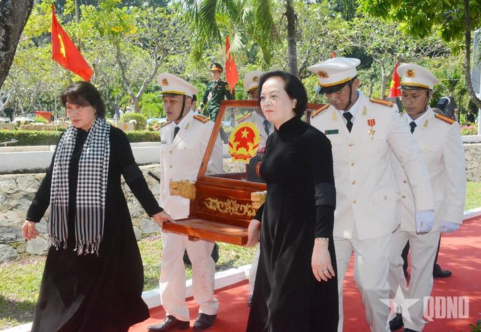 Nguyên Chủ tịch Quốc hội Nguyễn Thị Kim Ngân và đồng chí Phạm Thị Thanh Trà, Bí thư Trung ương Đảng, Phó thủ tướng Chính phủ, Trưởng ban Chỉ đạo quốc gia về tìm kiếm, quy tập và xác định danh tính hài cốt liệt sĩ thành kính di quách hài cốt liệt sĩ đến vị trí an táng. Ảnh: HOÀNG THÀNH