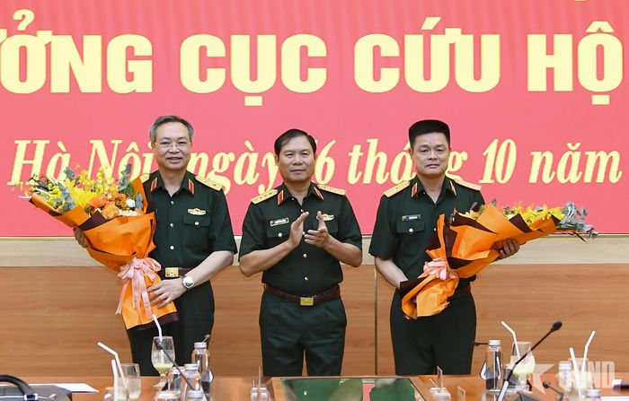  Đại tướng Nguyễn Tân Cương tặng hoa chúc mừng Trung tướng Doãn Thái Đức và Thiếu tướng Vũ Hồng Anh.  