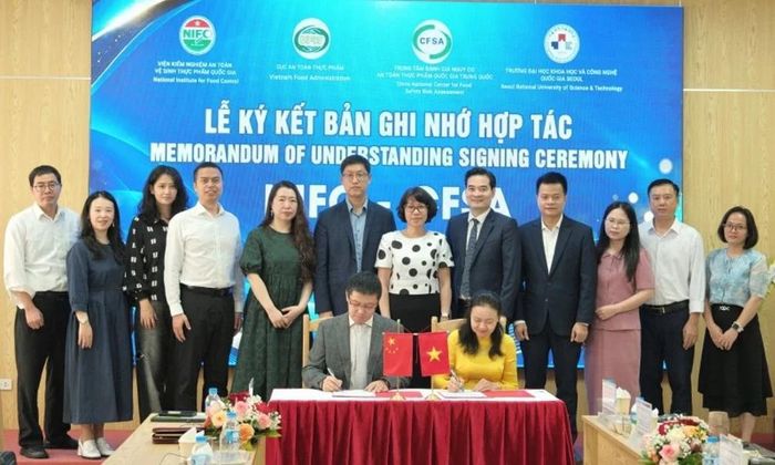  Đại diện NIFC và Trung tâm Đánh giá nguy cơ an toàn thực phẩm quốc gia Trung Quốc ký biên bản ghi nhớ hợp tác. Ảnh: TRẦN MINH 