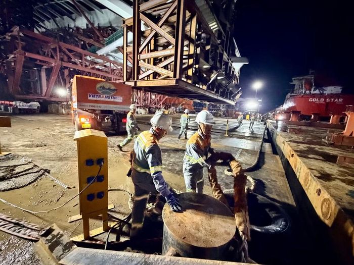 Công nhân kiểm tra dây cáp và thiết bị chuyên dụng, chuẩn bị đưa kết cấu vòm thép cầu đi bộ qua sông Sài Gòn xuống sà lan. Ảnh: Hoàng Hùng