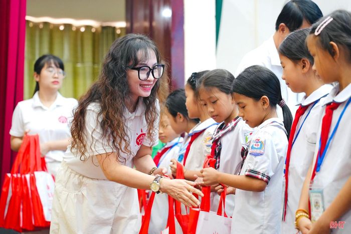 Đại diện Tổ chức Zhishan Foundation trao học bổng và quà cho các em học sinh.