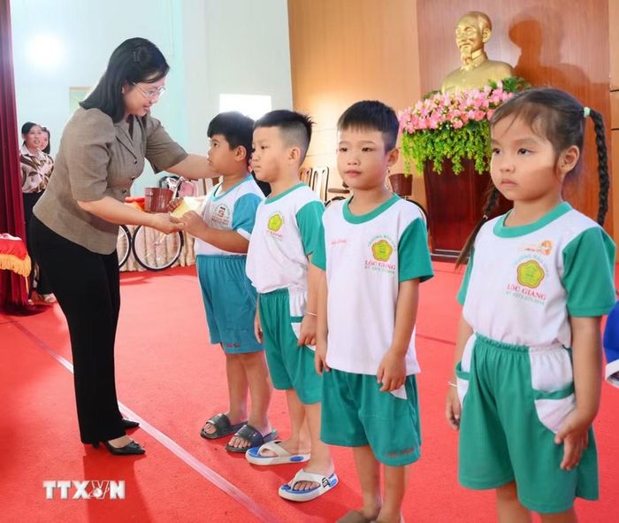 Bà Nguyễn Hoàng Uyên, Phó Giám đốc Sở Y tế Tây Ninh trao quà, động viên các em học sinh có hoàn cảnh khó khăn tại chương trình chăm lo an sinh xã hội. (Ảnh: Thanh Bình/TTXVN)