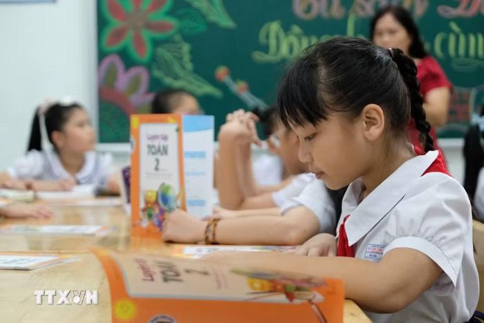 Học sinh Trường Tiểu học Tây Nha Trang - phân hiệu 2 (phường Tây Nha Trang, Khánh Hòa) tham khảo bộ sách trong tủ sách Đinh Hữu Dư. (Ảnh: Nguyễn Dũng/TTXVN)