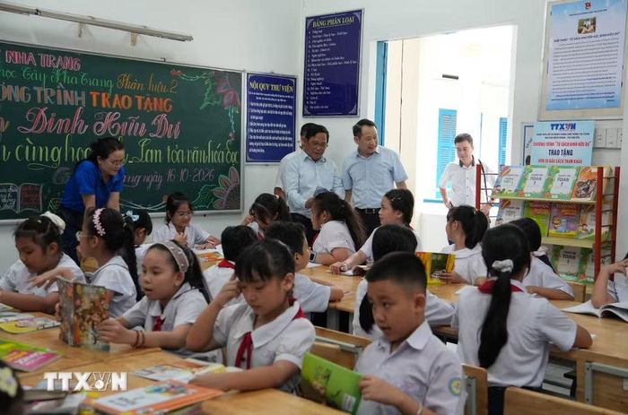 Các đại biểu và học sinh tham quan khu vực tủ sách Đinh Hữu Dư bố trí trong thư viện của Trường Tiểu học Tây Nha Trang. (Ảnh: Nguyễn Dũng/TTXVN)