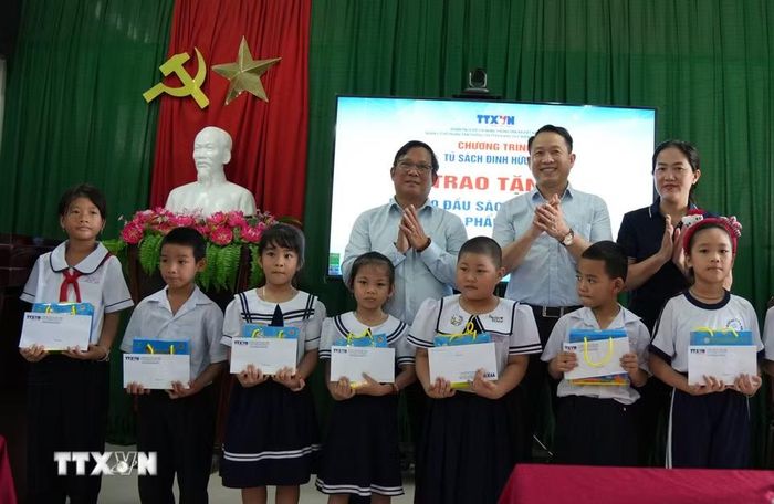 Lãnh đạo Trung tâm Thông tin TTXVN khu vực miền Trung-Tây Nguyên cùng các đại biểu trao tặng 20 suất học bổng cho học sinh có hoàn cảnh khó khăn của trường Tiểu học Tây Nha Trang. (Ảnh: Nguyễn Dũng/TTXVN)