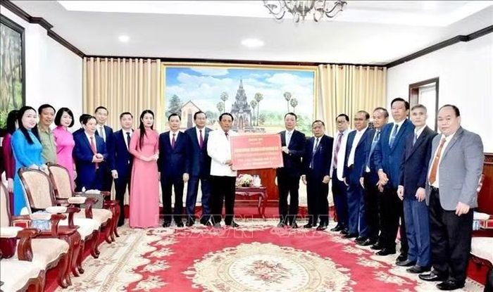 Thay mặt Đảng bộ, chính quyền và nhân dân tỉnh Hà Tĩnh, đồng chí Phan Thiên Định trao 200 triệu đồng hỗ trợ tỉnh Savannakhet khắc phục hậu quả thiên tai. Ảnh: Xuân Tú/PV TTXVN tại Lào