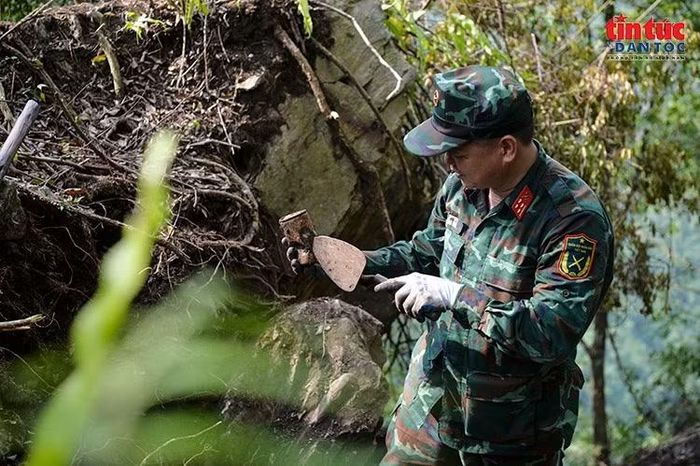 Kiểm tra vật dụng được phát hiện trong quá trình tìm kiếm hài cốt liệt sĩ tại hiện trường. Ảnh: LP