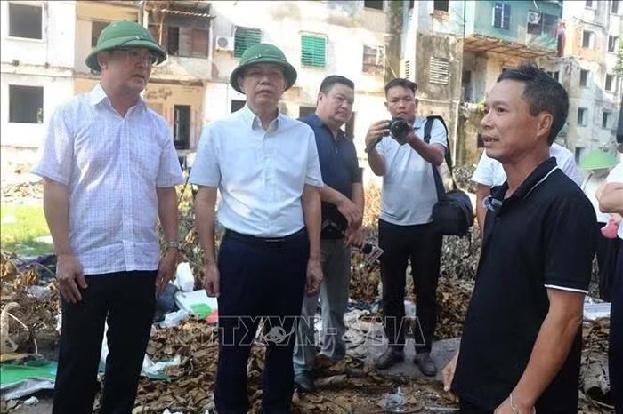 Lãnh đạo phường Thành Vinh vận động các hộ dân sớm di dời khỏi khu chung cư xuống cấp. Ảnh: Trịnh Duy Hưng/TTXVN