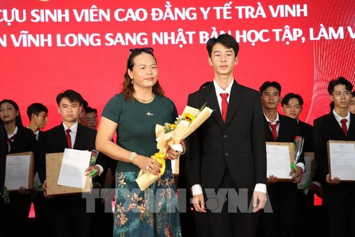 Em Lương Quang Nhựt, xã Hiệp Mỹ tặng hoa tri ân mẹ tại buổi lễ, cảm ơn gia đình đã luôn yêu thương, đồng hành tgiúp em có thể sang Nhật Bản học tập, làm việc. Ảnh: Thanh Hòa- TTXVN