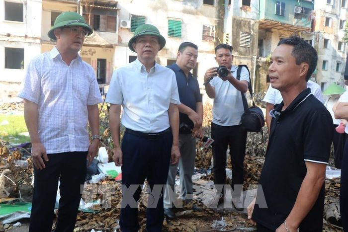 Lãnh đạo phường Thành Vinh vận động các hộ dân sớm di rời khỏi khu chung cư xuống cấp. Ảnh: Trịnh Duy Hưng-TTXVN