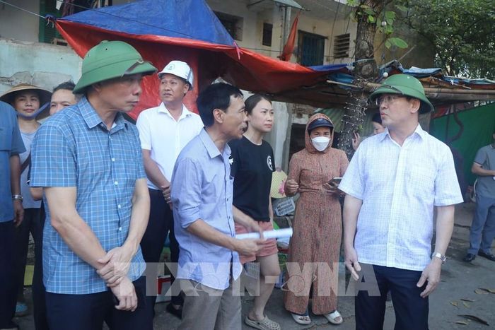 Lãnh đạo phường Thành Vinh vận động các hộ dân sớm di rời khỏi khu chung cư xuống cấp. Ảnh: Trịnh Duy Hưng-TTXVN