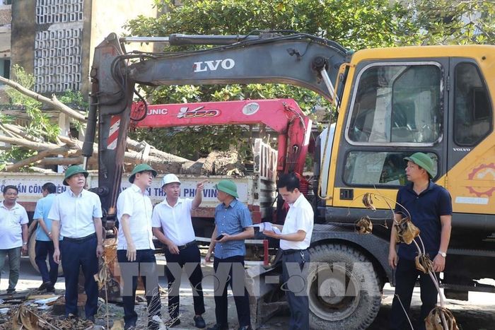 Lãnh đạo phường Thành Vinh vận động các hộ dân sớm di rời khỏi khu chung cư xuống cấp. Ảnh: Trịnh Duy Hưng-TTXVN