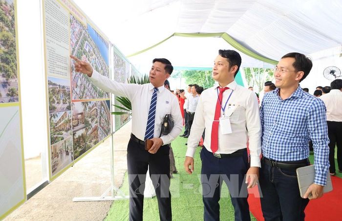 Đại diện các doanh nghiệp giới thiệu sản phẩm, trao đổi thông tin với lãnh đạo phường Bình Phước và các đại biểu tại khu vực trưng bày. Ảnh: Đậu Tất Thành - TTXVN