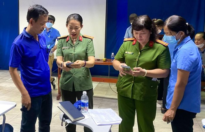 Thượng tá Nông Thị Minh Huệ (thứ 2 từ trái qua) cùng đồng đội hướng dẫn người dân tích hợp định danh điện tử.