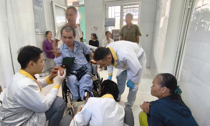 Các thành viên của tổ công tác hỗ trợ người dân thực hiện lấy mẫu máu. Ảnh: HỒNG NĂM