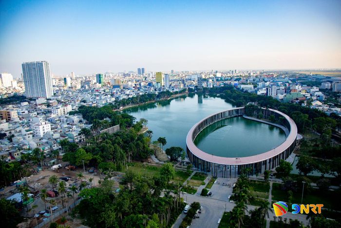 Nhìn từ trên cao, công trình gây ấn tượng với hình khối elip độc đáo, nổi bật giữa mặt nước và những mảng xanh của công viên. Ảnh: BẢO LÂM