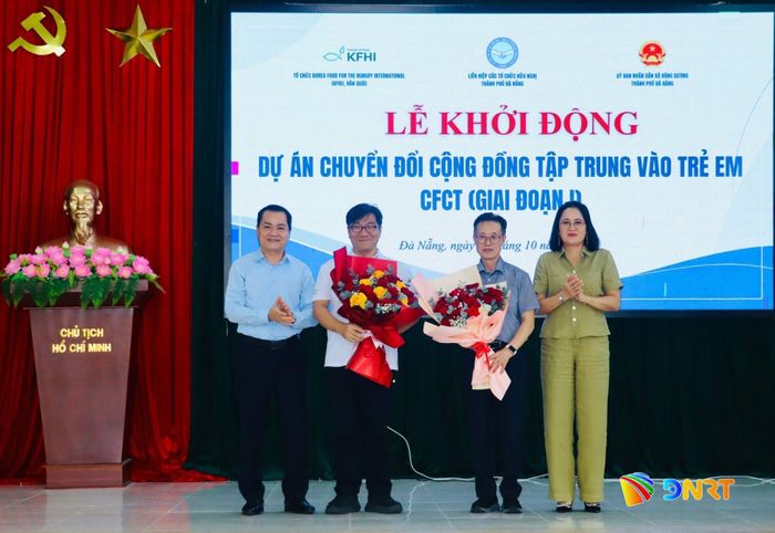 Lãnh đạo xã Đồng Dương tặng hoa tri ân đơn vị tài trợ dự án. Ảnh: QUỐC TUẤN