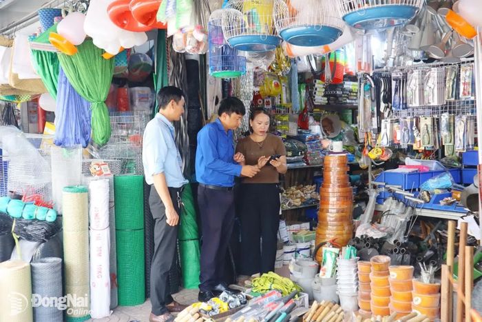 Tổ Công nghệ số cộng đồng phường Bình Phước hướng dẫn người dân cài đặt và sử dụng các ứng dụng số. Ảnh: Nhã Trâm