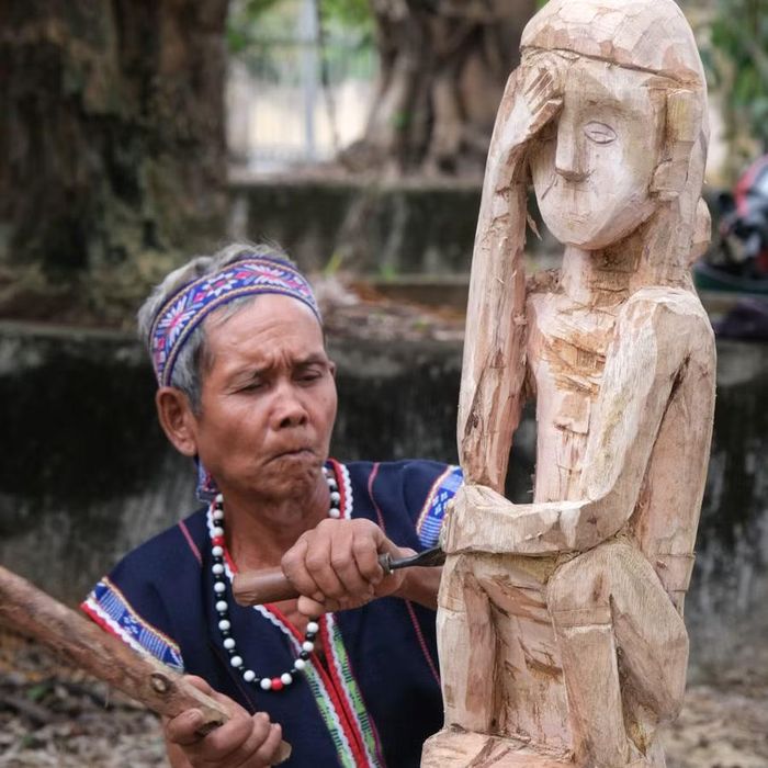  Nghệ nhân ưu tú Đinh Uế (làng Pyang Dơng) tạc tượng phụ nữ ôm mặt - mẫu tượng truyền thống trong lễ bỏ mả của người Bahnar. Ảnh: Hoàng Ngọc 