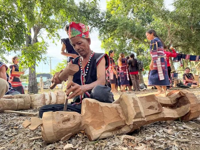  Nghệ nhân Đinh Bri (làng Byang Dơng) đang hoàn thiện bức tượng đàn ông đánh trống. Ảnh: Hoàng Ngọc 