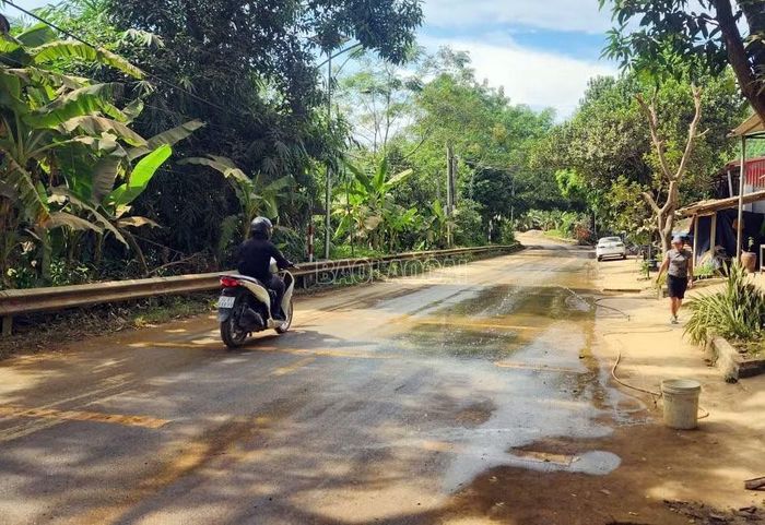 Người dân thôn Khe Phàn, xã Văn Bàn, thường xuyên phải phun nước rửa đường do bụi quặng phủ dày.