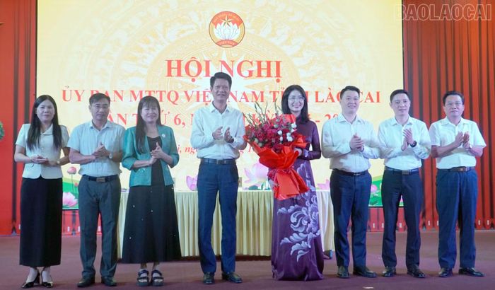Đồng chí Nguyễn Thế Phước, đồng chí Hà Đức Minh cùng lãnh đạo Ủy ban Mặt trận Tổ quốc tỉnh và các đoàn thể tặng hoa chúc mừng đồng chí Nguyễn Thị Ngà.